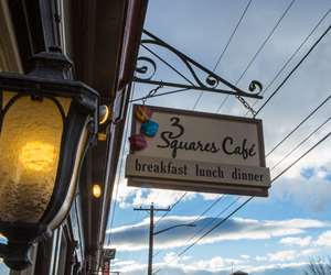 3 Squares Cafe sign with a cloudy sky background