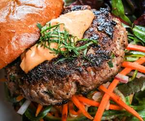 Close up of Pork burger with carrot slaw and sriracha aioli 