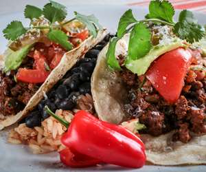 Two ground beef tacos with rice and beans 